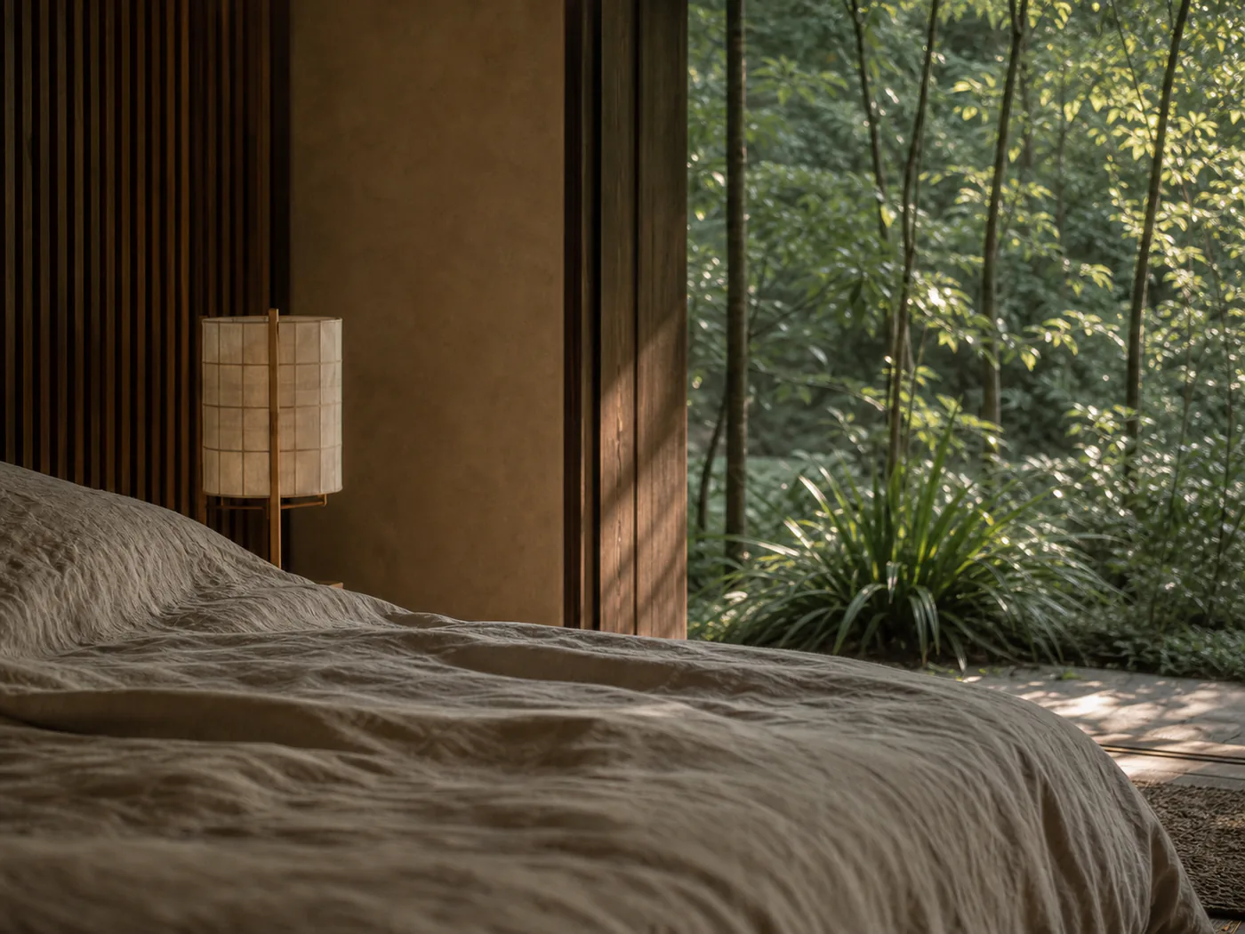 Close view of a linen-dressed bed beside a low timber window.