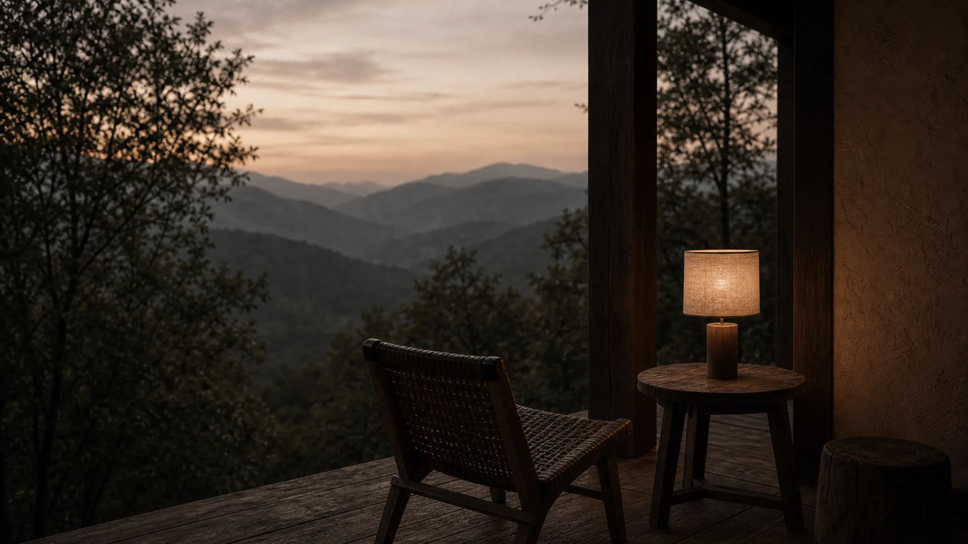 A room at dusk, one lamp lit and the garden dark beyond the glass.